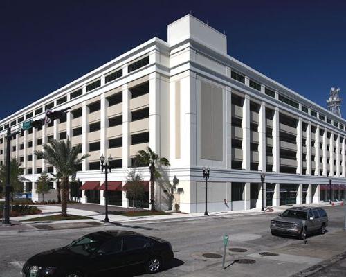 Exterior photo of the City of Jacksonville parking garage. Middle of the day as cars drive by.