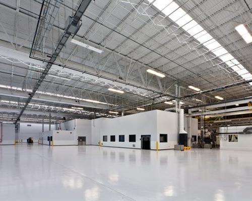 Interior of the Rolls Royce Crosspointe Rotatives Facility. Large, industrial, open space with fluorescent lighting.