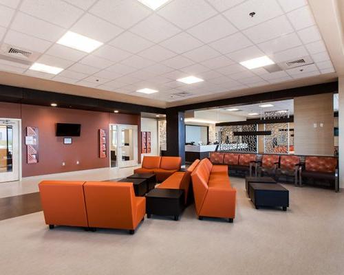 Waiting area inside the TMC Rincon Health Campus. Orange chairs and brown tables sit in the middle of the room.